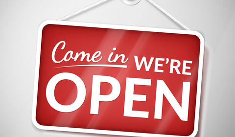 Imagem de uma placa com o escrito "Entre, estamos abertos" em inglês
