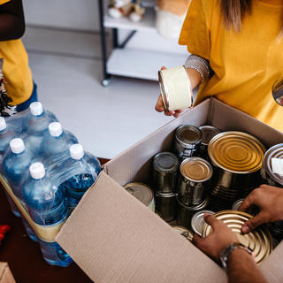 Pessoas separando alimentos enlatados para doação