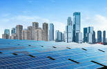 Imagem de fileiras de painéis de energia solar com diversos prédios ao fundo