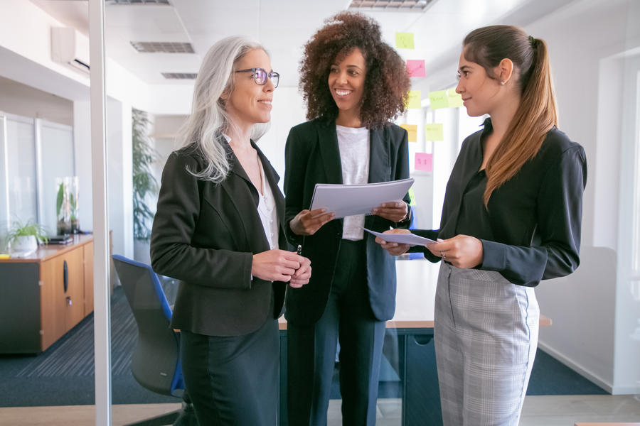 mulheres no ambiente corporativo conversando e trabalhando